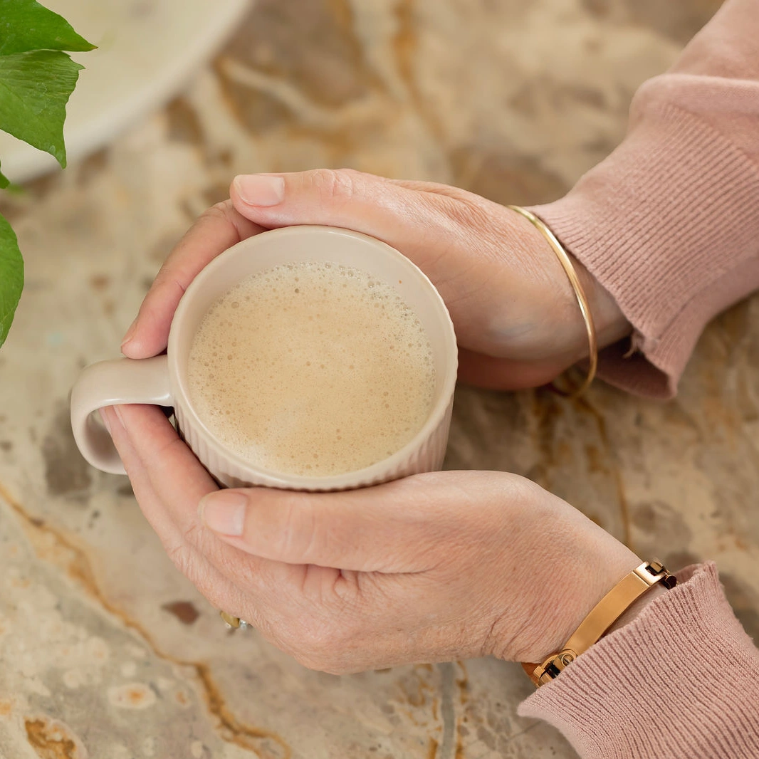 Hands wrapped around a cup of coffee